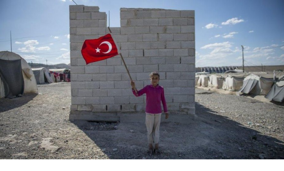 Szíriai gyermek török zászlóval a kezében a Gaziantep melletti menekülttáborban